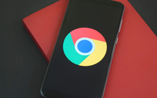 Smartphone på rød baggrund, der symboliserer digital optimering og synlighed gennem Google My Business.